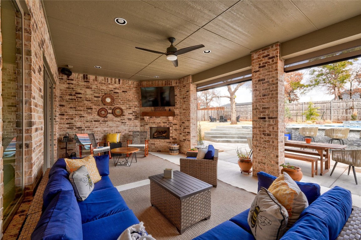 5008 Isle Bridge Court, Edmond, OK 73034 view of patio / terrace with an outdoor living space with a fireplace and ceiling fan