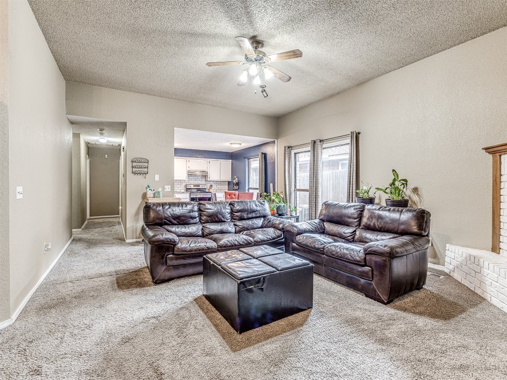 8104 NW 78th Terrace, Oklahoma City, OK 73132 carpeted living room with a textured ceiling and ceiling fan