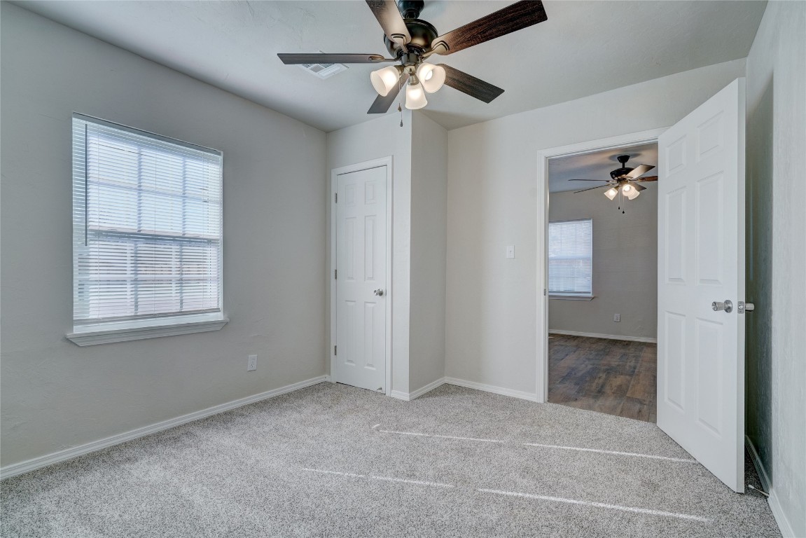 2817 SE 56th Street, Oklahoma City, OK 73129 unfurnished bedroom with multiple windows, dark carpet, and ceiling fan