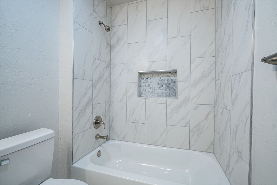 2817 SE 56th Street, Oklahoma City, OK 73129 bathroom featuring tiled shower / bath and toilet