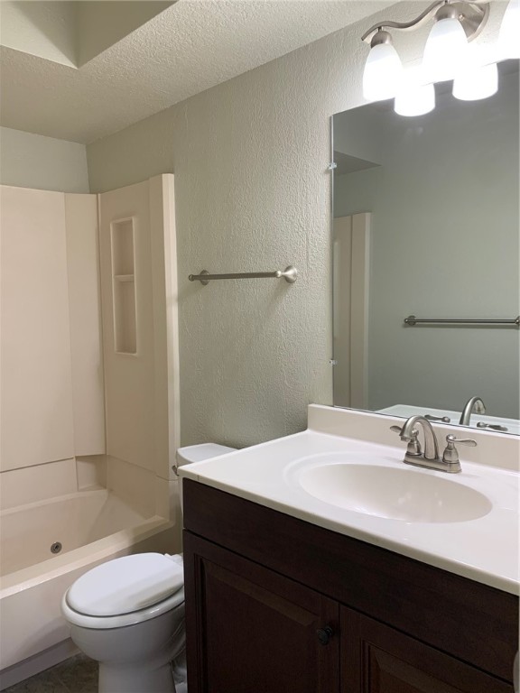 14319 N Pennsylvania Avenue, #15F, Oklahoma City, OK 73134 full bathroom with washtub / shower combination, toilet, a textured ceiling, and oversized vanity