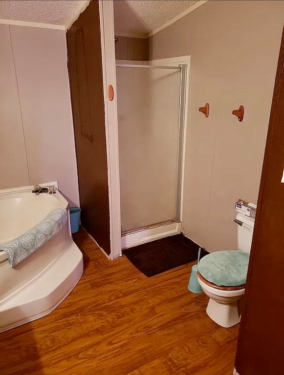 330844 E Lynne Lane, Harrah, OK 73045 bathroom featuring toilet, vaulted ceiling, hardwood / wood-style flooring, an enclosed shower, and a textured ceiling