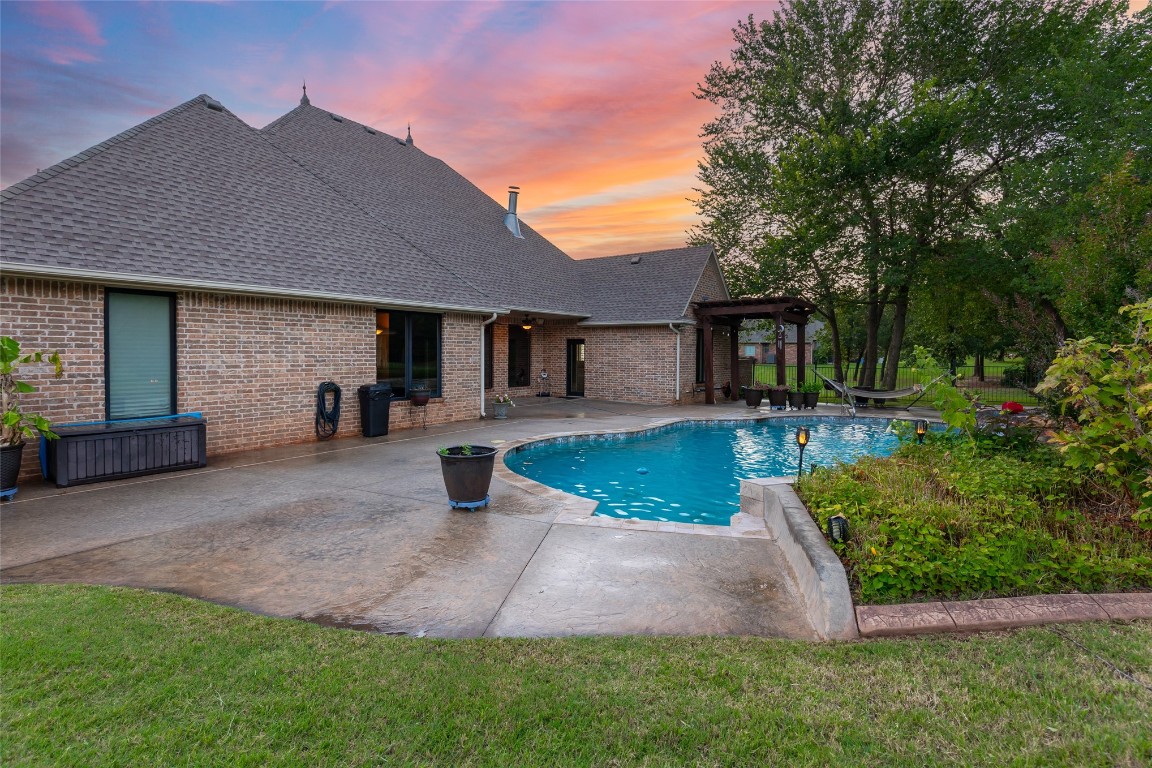 4508 Jacobs Lane, Choctaw, OK 73020 pool at dusk featuring a patio and a lawn