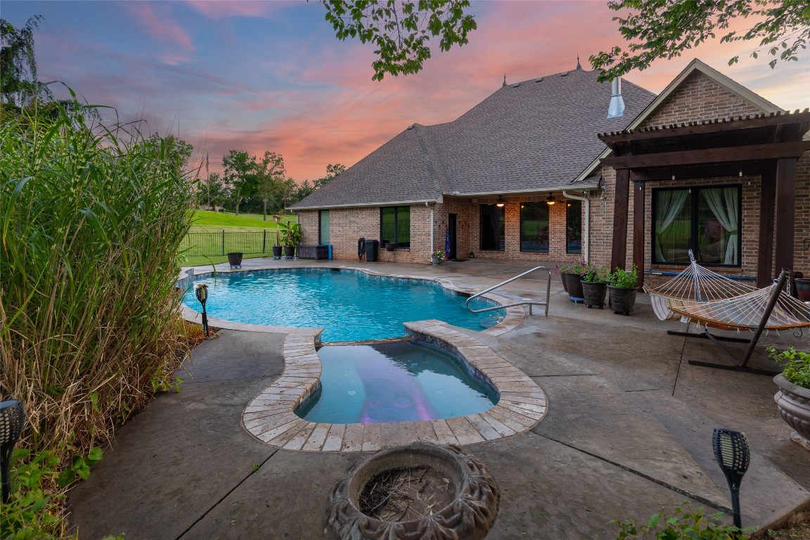 4508 Jacobs Lane, Choctaw, OK 73020 pool at dusk featuring an in ground hot tub and a patio