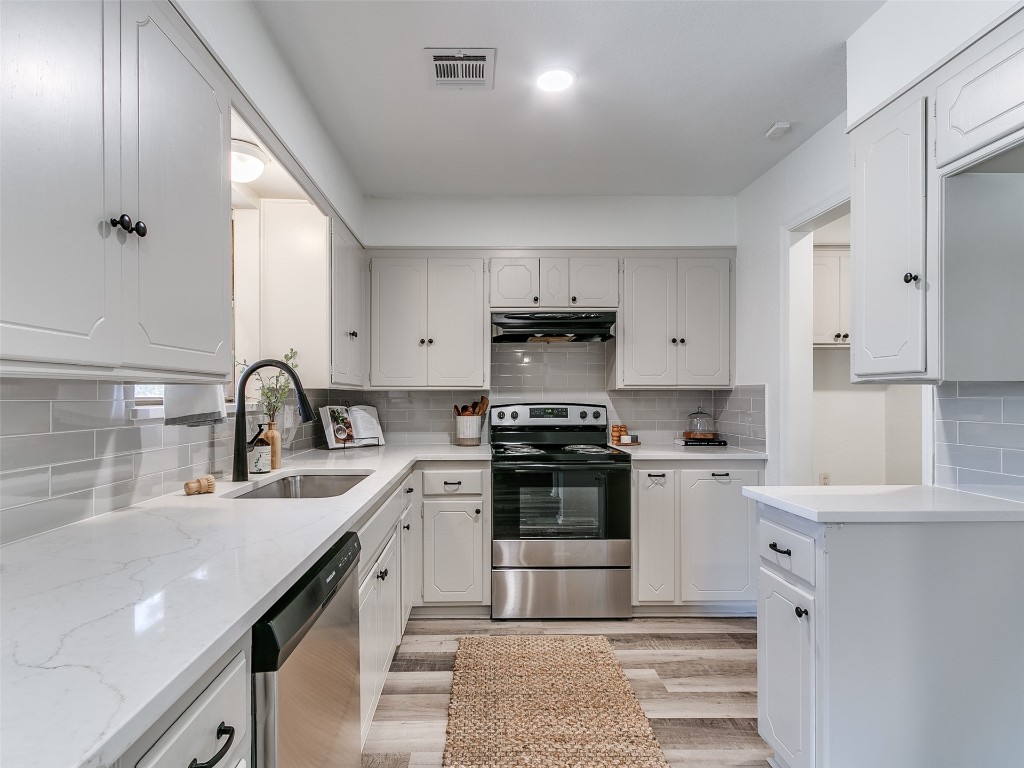 908 NW Van Buren Avenue, Piedmont, OK 73078 kitchen featuring light hardwood / wood-style floors, white cabinets, tasteful backsplash, sink, and stainless steel appliances