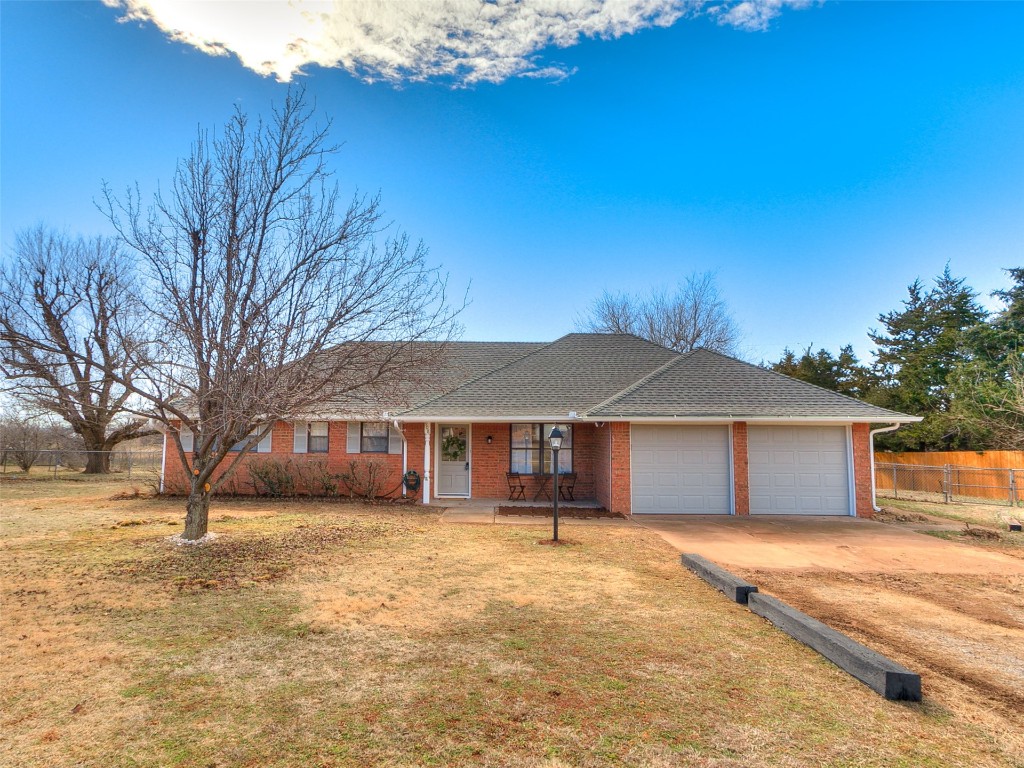 908 NW Van Buren Avenue, Piedmont, OK 73078 ranch-style home featuring a front lawn and a garage
