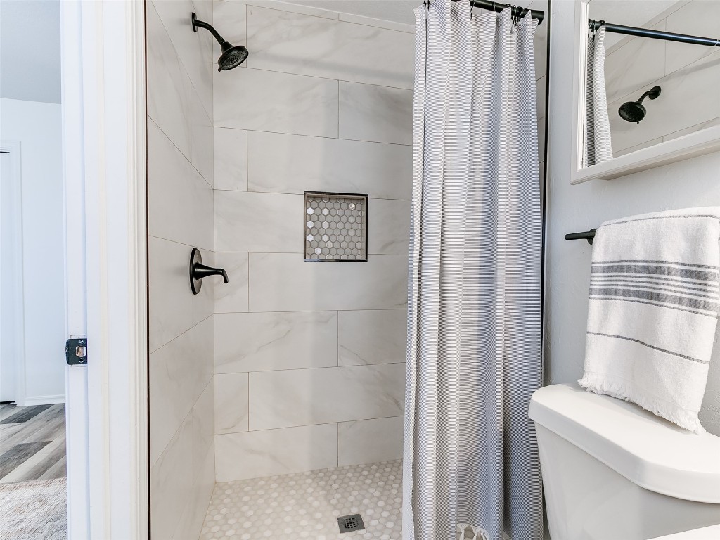 908 NW Van Buren Avenue, Piedmont, OK 73078 bathroom featuring a shower with curtain, hardwood / wood-style flooring, and toilet