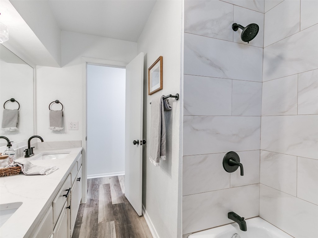 908 NW Van Buren Avenue, Piedmont, OK 73078 bathroom with dual vanity, tiled shower / bath, and wood-type flooring