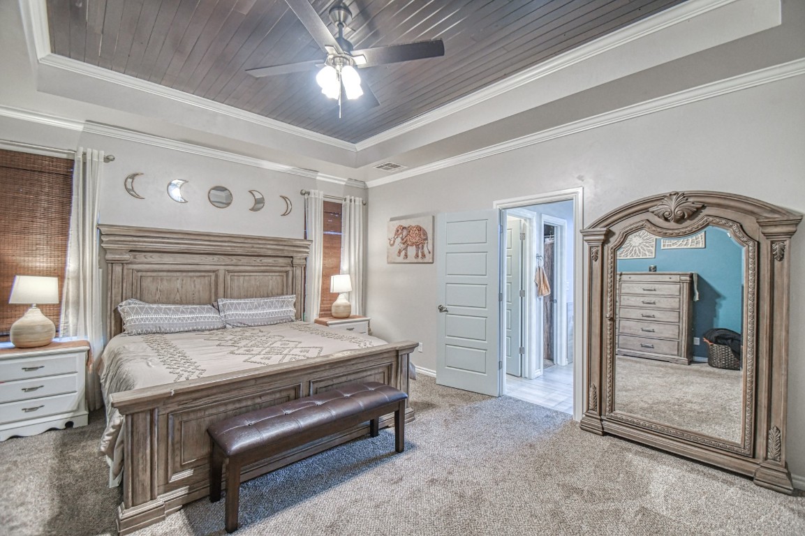 3935 Huntington Parkway, Choctaw, OK 73020 carpeted bedroom featuring crown molding, wood ceiling, and ceiling fan