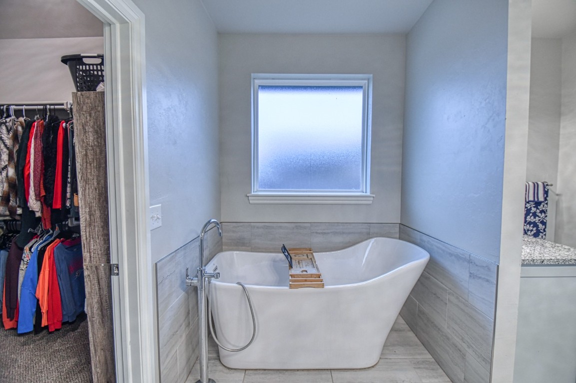 3935 Huntington Parkway, Choctaw, OK 73020 bathroom featuring tile walls, vanity, and a tub