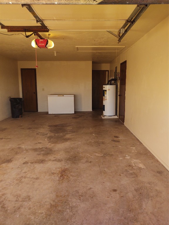 1240 COUNTY Road, Carnegie, OK 73015 garage with a garage door opener, fridge, and water heater
