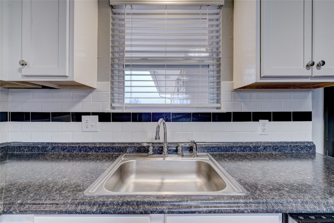 44 SE 57th Street, Oklahoma City, OK 73129 kitchen featuring sink, tasteful backsplash, and white cabinetry