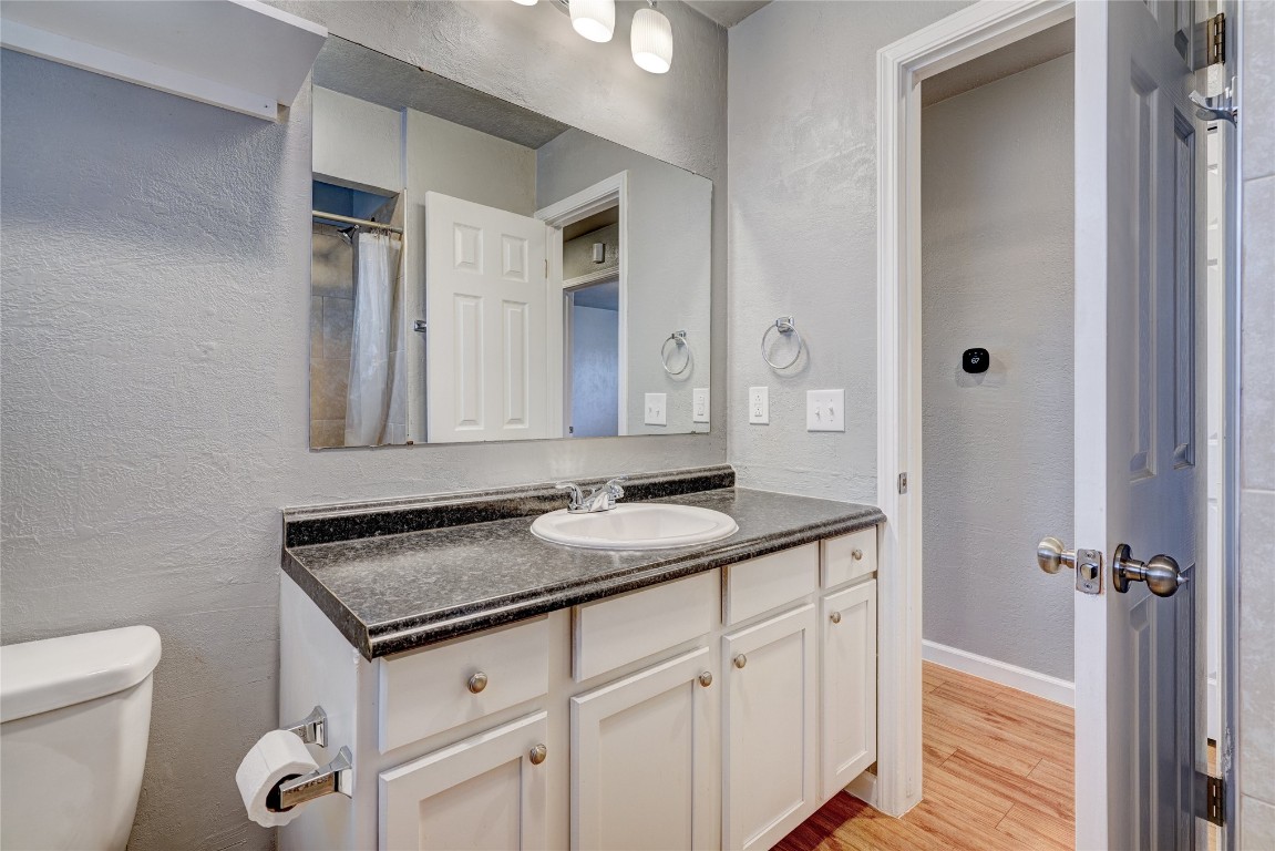 44 SE 57th Street, Oklahoma City, OK 73129 bathroom featuring toilet, large vanity, and hardwood / wood-style flooring