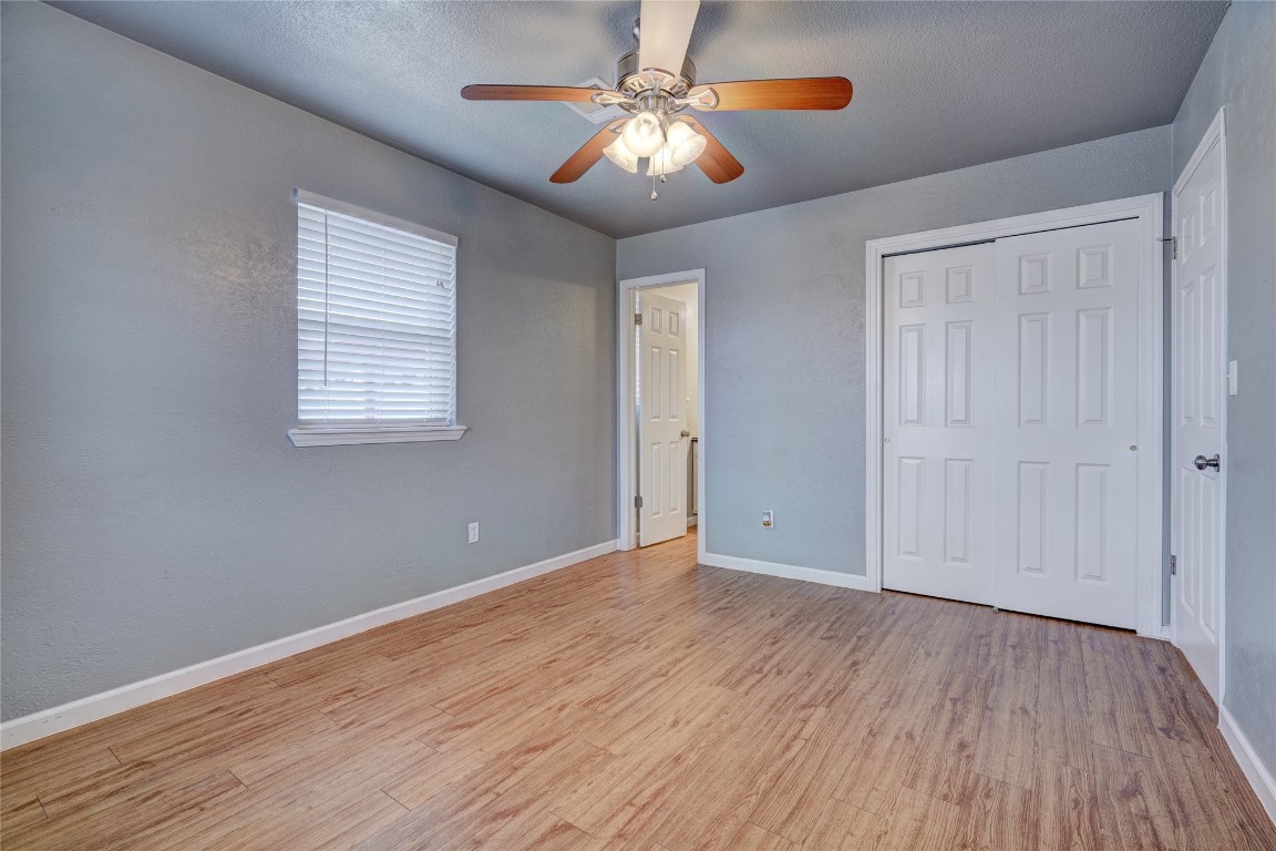 44 SE 57th Street, Oklahoma City, OK 73129 unfurnished bedroom featuring light hardwood / wood-style flooring, a closet, and ceiling fan