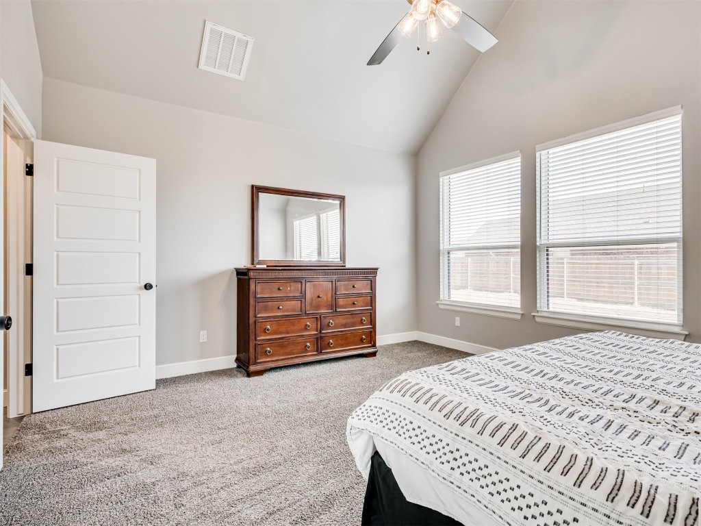 4512 Hidalgo Avenue, Mustang, OK 73064 bedroom featuring dark carpet, ceiling fan, and high vaulted ceiling