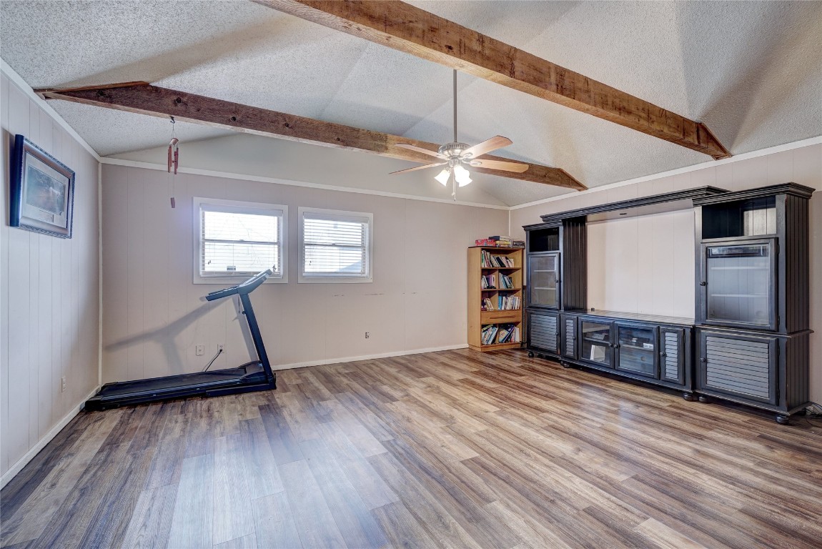 2505 N Hammond Avenue, Oklahoma City, OK 73127 interior space featuring wood-type flooring, vaulted ceiling with beams, ceiling fan, and a textured ceiling