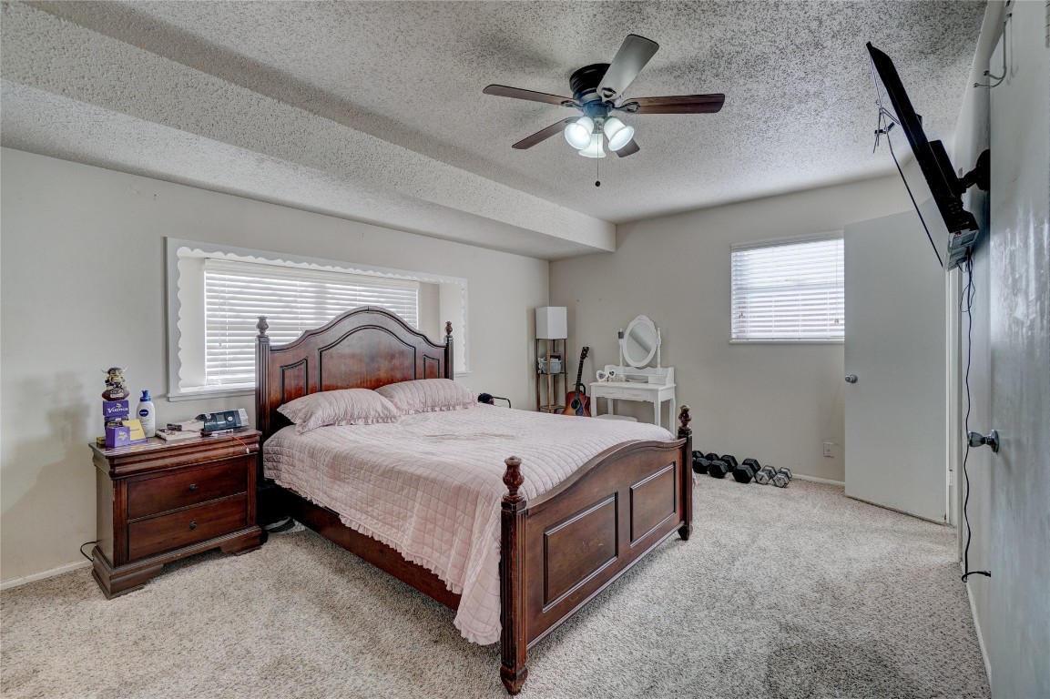 2505 N Hammond Avenue, Oklahoma City, OK 73127 carpeted bedroom with ceiling fan, a textured ceiling, and multiple windows