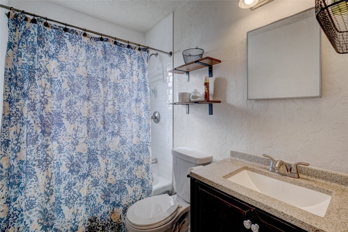 2505 N Hammond Avenue, Oklahoma City, OK 73127 full bathroom with vanity, toilet, a textured ceiling, and shower / bath combo with shower curtain