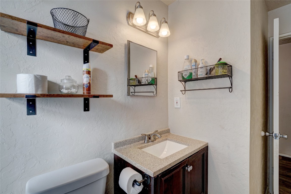 2505 N Hammond Avenue, Oklahoma City, OK 73127 bathroom with hardwood / wood-style flooring, vanity, and toilet