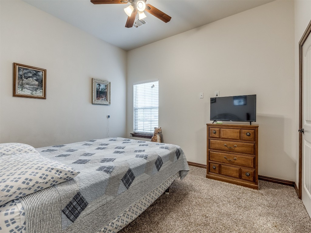 10900 NW 96th Street, Yukon, OK 73099 bedroom featuring ceiling fan and light colored carpet