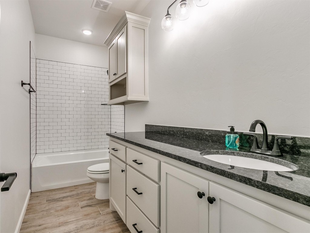 1226 Deer Ridge Boulevard, Tuttle, OK 73089 full bathroom with vanity, toilet, tiled shower / bath, and wood-type flooring