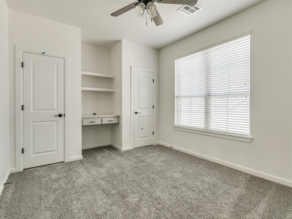 1226 Deer Ridge Boulevard, Tuttle, OK 73089 unfurnished bedroom featuring light carpet, ceiling fan, and multiple windows
