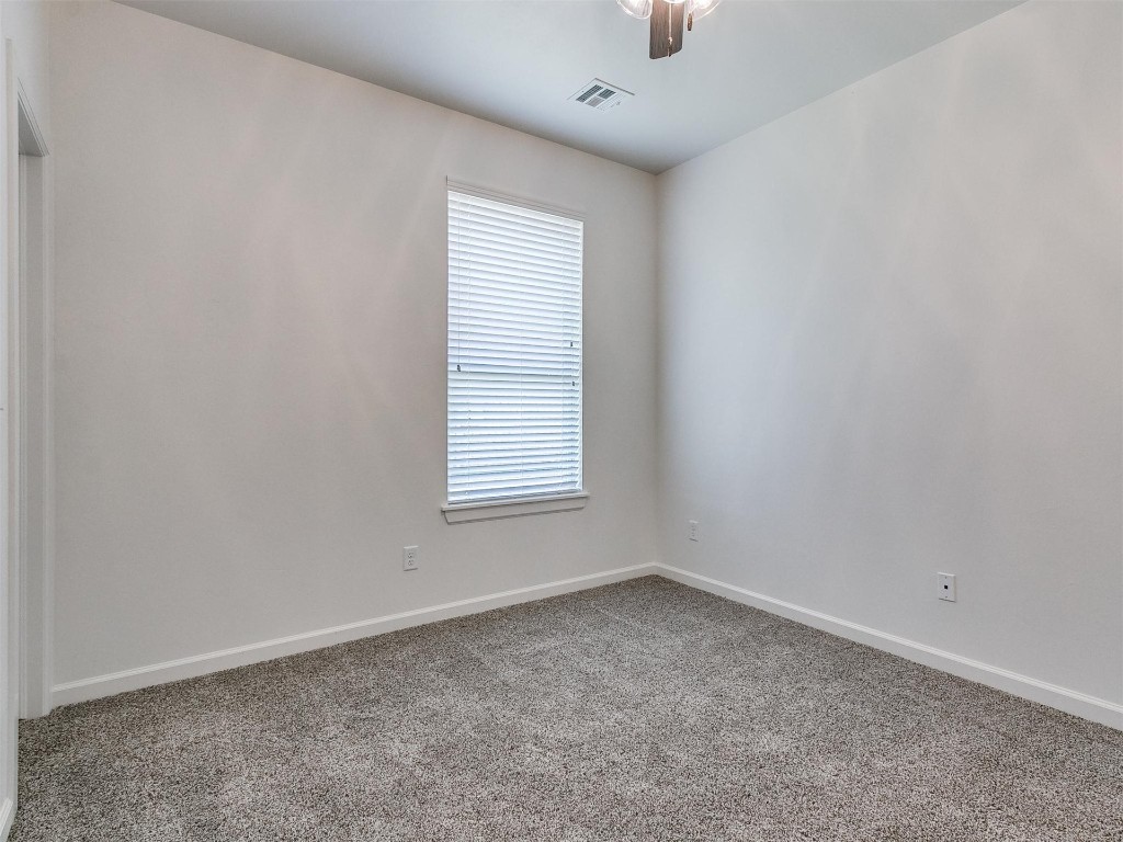 1226 Deer Ridge Boulevard, Tuttle, OK 73089 empty room with dark carpet and ceiling fan