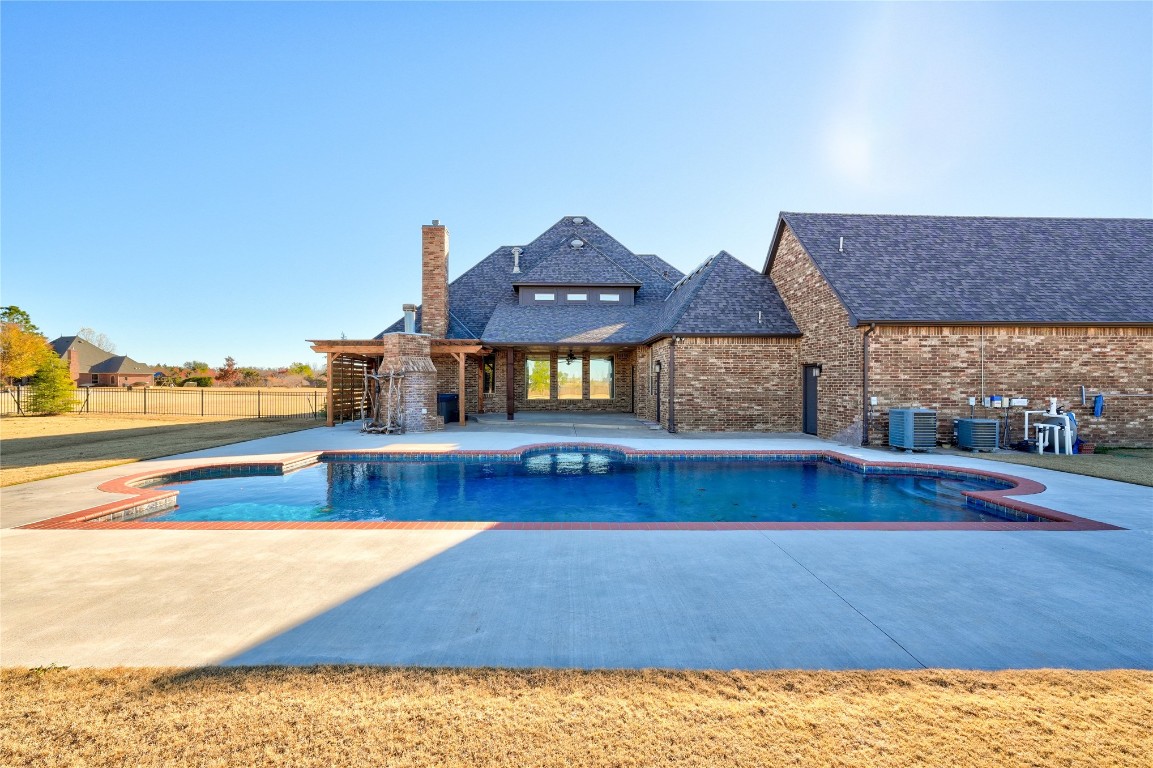 2355 La Belle Rue, Edmond, OK 73034 view of pool with central AC unit, a hot tub, and a patio