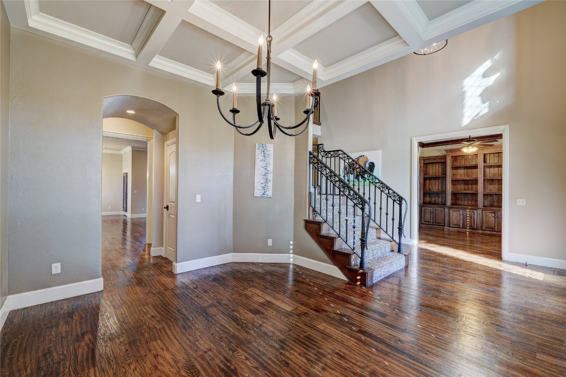2355 La Belle Rue, Edmond, OK 73034 interior space featuring coffered ceiling, ceiling fan with notable chandelier, beamed ceiling, and dark wood-type flooring