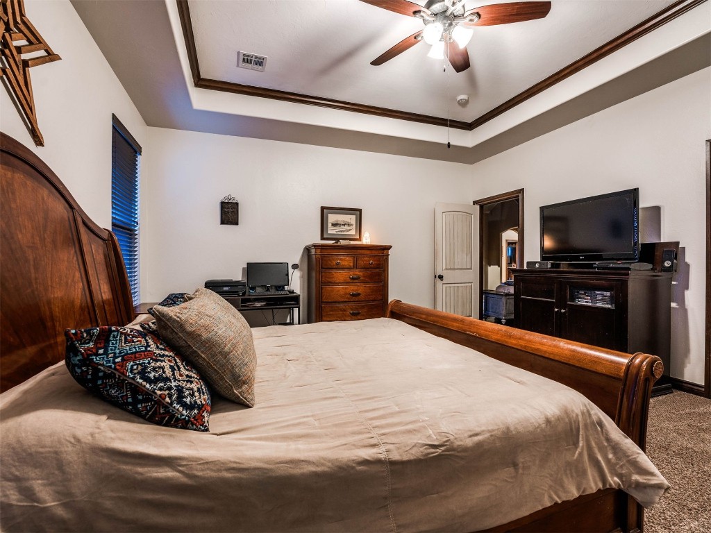 112 Old Home Place, Yukon, OK 73099 bedroom with ceiling fan, a raised ceiling, and carpet