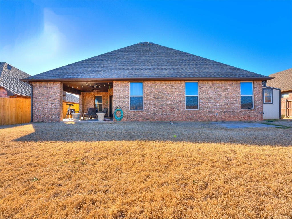 112 Old Home Place, Yukon, OK 73099 back of property with a patio area and a lawn