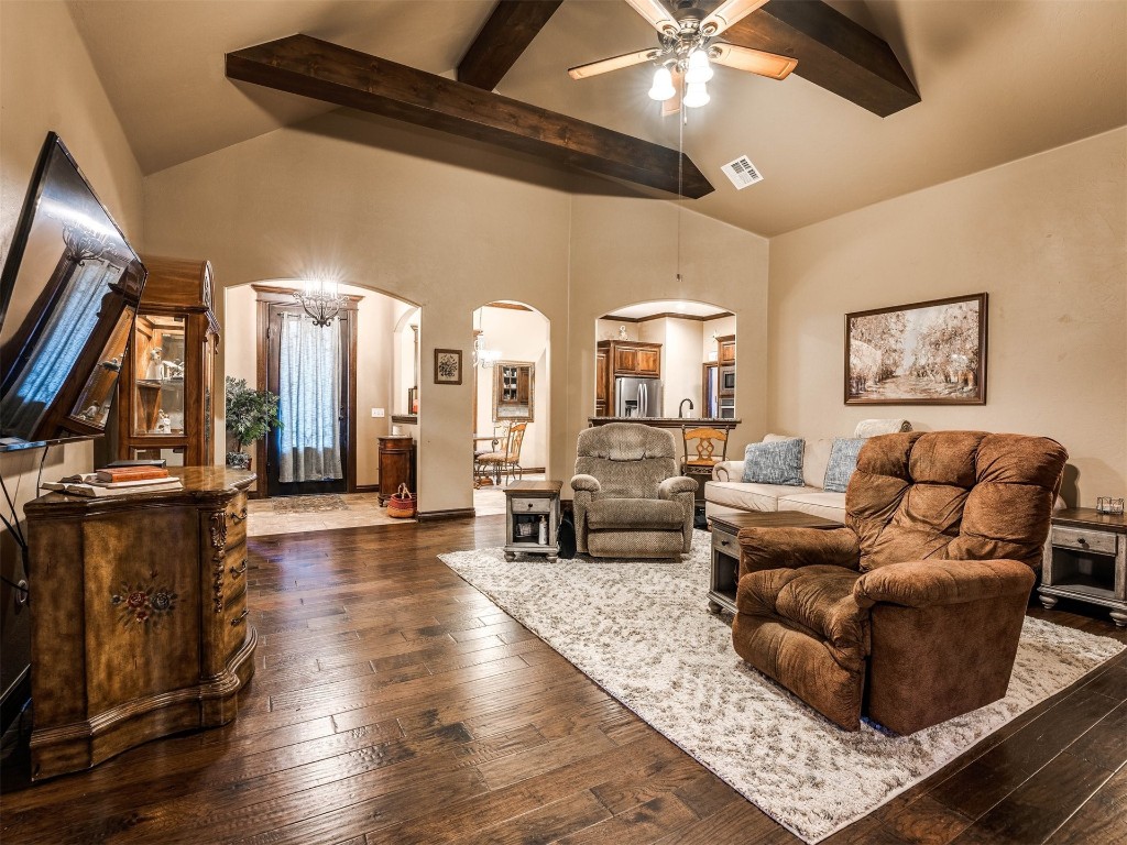 112 Old Home Place, Yukon, OK 73099 living room featuring dark hardwood / wood-style floors, beam ceiling, ceiling fan with notable chandelier, and high vaulted ceiling
