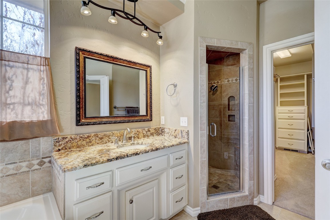 1941 Oak Creek Terrace, Edmond, OK 73034 bathroom featuring vanity, walk in shower, and tile floors