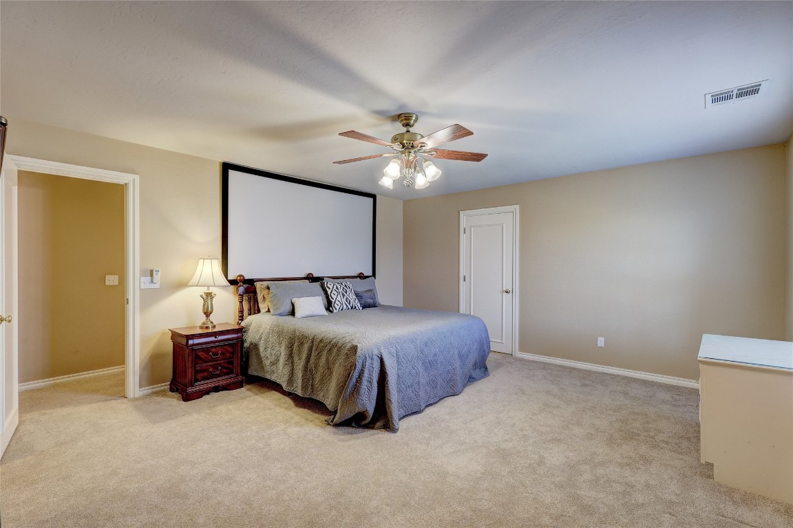 1941 Oak Creek Terrace, Edmond, OK 73034 bedroom featuring light carpet and ceiling fan