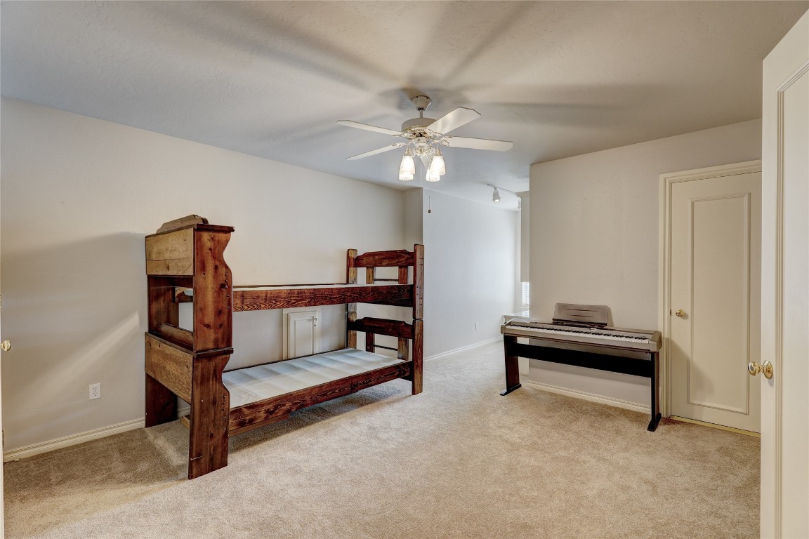 1941 Oak Creek Terrace, Edmond, OK 73034 bedroom featuring light carpet and ceiling fan