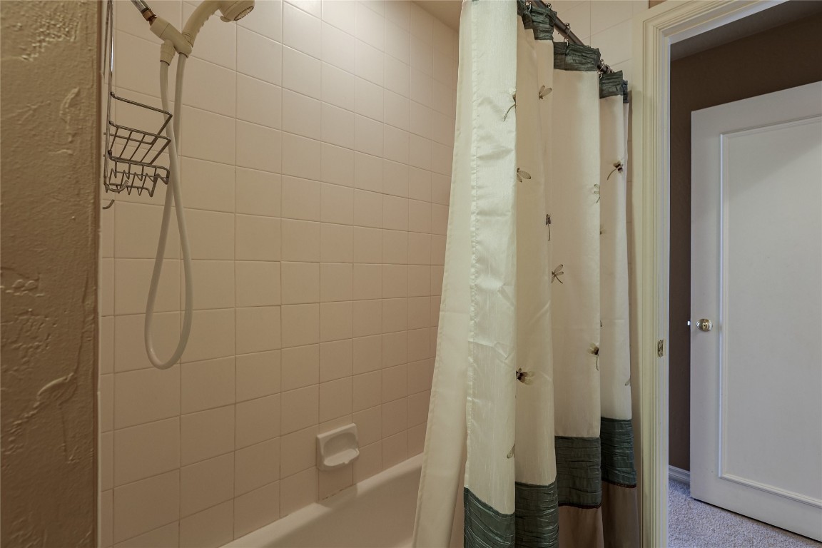 1941 Oak Creek Terrace, Edmond, OK 73034 bathroom featuring shower / bath combo with shower curtain