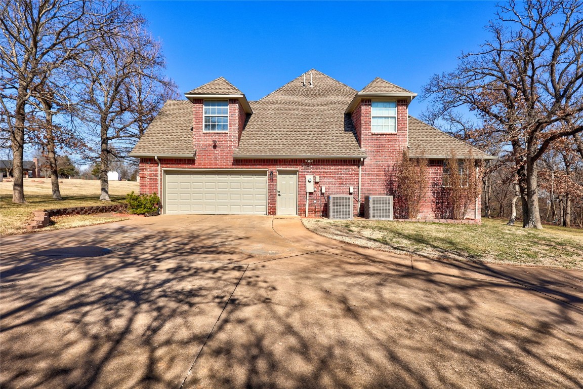1941 Oak Creek Terrace, Edmond, OK 73034 view of front of property with a garage and central AC unit