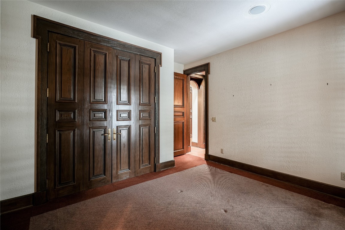 3900 S Bryant Avenue, Edmond, OK 73013 unfurnished bedroom featuring dark carpet and a closet