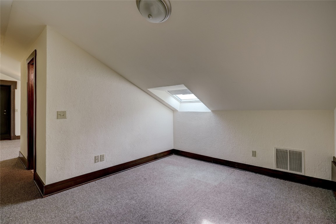 3900 S Bryant Avenue, Edmond, OK 73013 additional living space with lofted ceiling with skylight and carpet