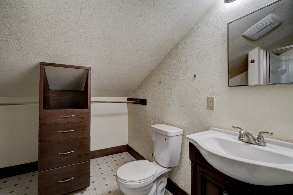 3900 S Bryant Avenue, Edmond, OK 73013 bathroom featuring vanity, tile floors, a textured ceiling, and toilet