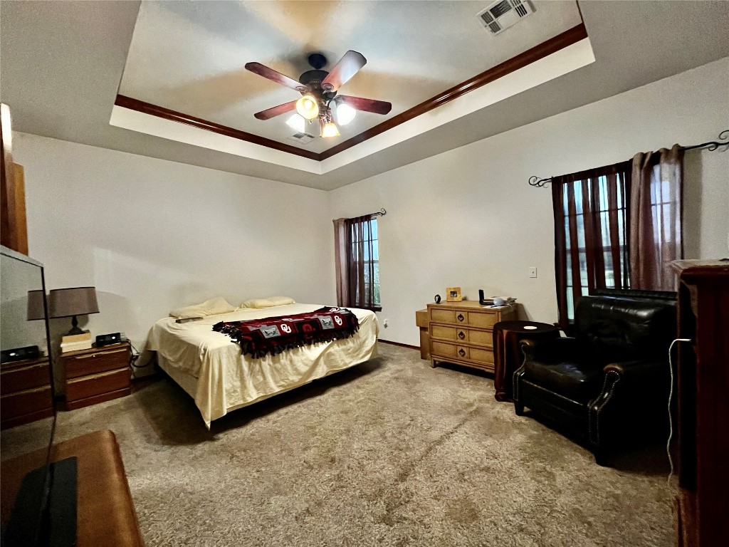 5808 E McMillin Dr, Tuttle, OK 73089 carpeted bedroom with a raised ceiling and ceiling fan