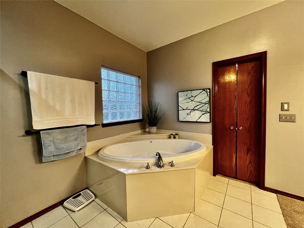 5808 E McMillin Dr, Tuttle, OK 73089 bathroom featuring a bathtub and tile floors