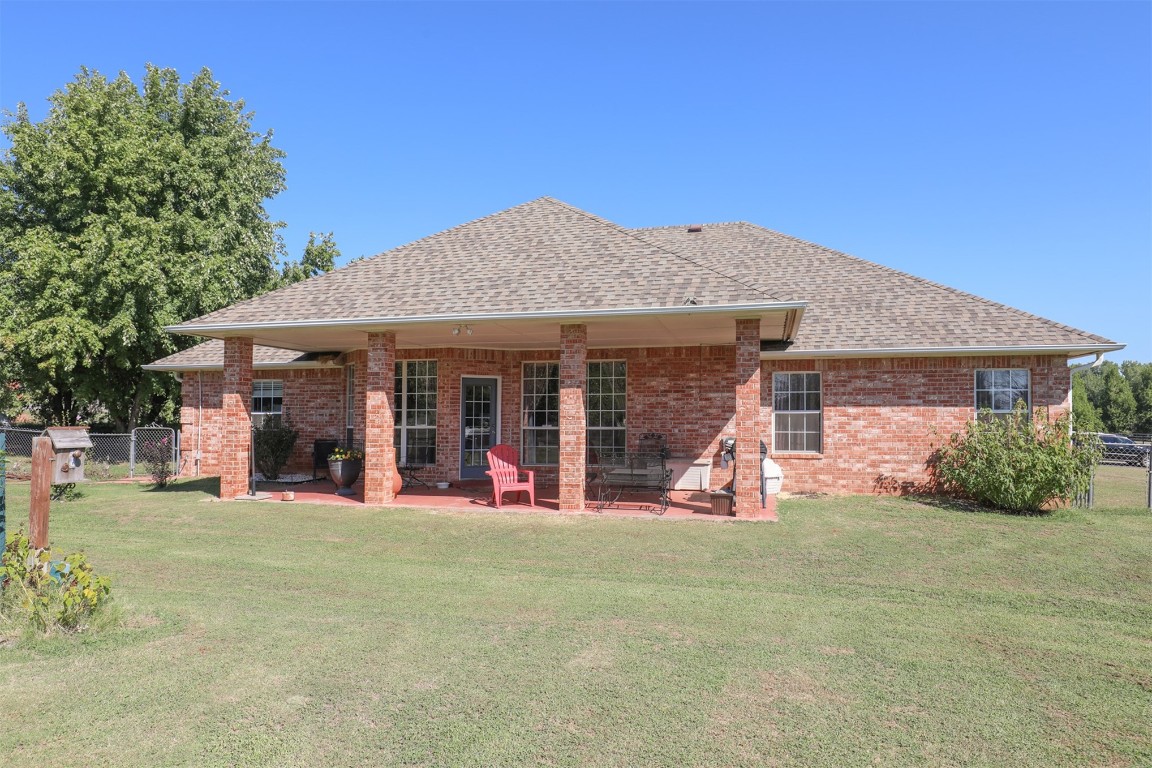 5808 E McMillin Dr, Tuttle, OK 73089 rear view of property featuring a patio area and a lawn