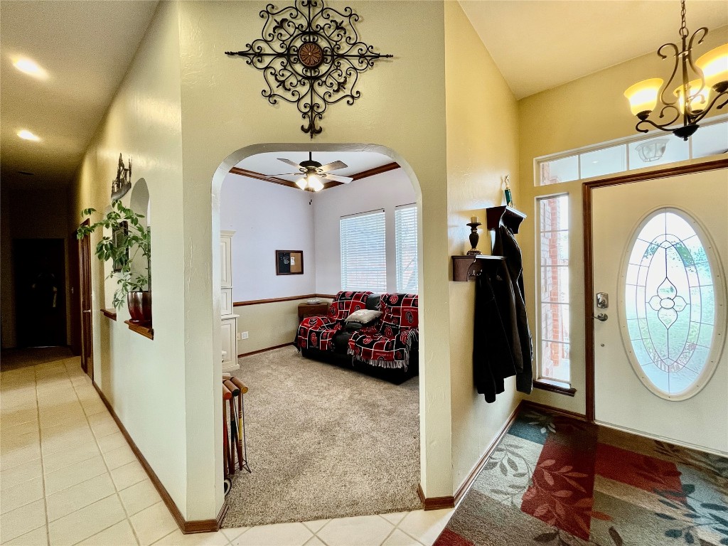 5808 E McMillin Dr, Tuttle, OK 73089 carpeted foyer featuring ceiling fan with notable chandelier