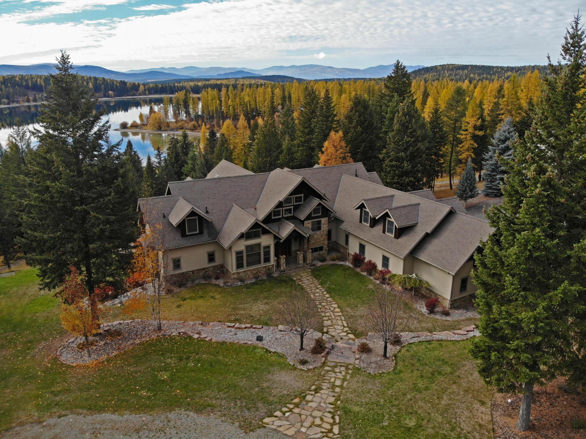 Leave the world behind at this lakefront estate perched on the rolling hills of Glen Lake. The serene setting of mature trees, manicured lawns and expansive decks is the perfect backdrop for a private Montana getaway. Situated at the center of 11 acres maximizing natural light and lake views, this home is a rare find boasting both lake frontage and complete privacy. Endless recreation awaits just minutes from Montana's #1 golf course and 45 min. from 2 world class ski resorts. The lakefront lot boasts over 200' of water front complete with docks and boat slips. Amenities include a theater room, commercial kitchen, spacious toy barn with guest suite and RV parking. See feature sheet for full details. Call Gretchen Lancaster 406-291-7099 or your real estate professional This home boasts a long list of amenities. The crowning features include; 1000+ sqft state of the art theater room with 13 stadium seats, 2592 sqft shop/boat storage with 850 sqft (1 bed, 2 bath finished guest quarters.) and a total of 6 car parking including the 3 car attached garage. 2 Master suites (one main level, one upstairs), a commercial grade kitchen, granite counter tops, large walk in pantry, bonus hockey play room, red oak floors throughout, coffered ceilings, 2 rock (gas) fireplaces, 3 laundry rooms, office/workout room, library, irrigation system around the home, built in speakers in nearly every room, Vantage lighting system, radiant floor heat, central air, central vacuum, security system, Venmar whole-house air circulation system and a walk in safe.