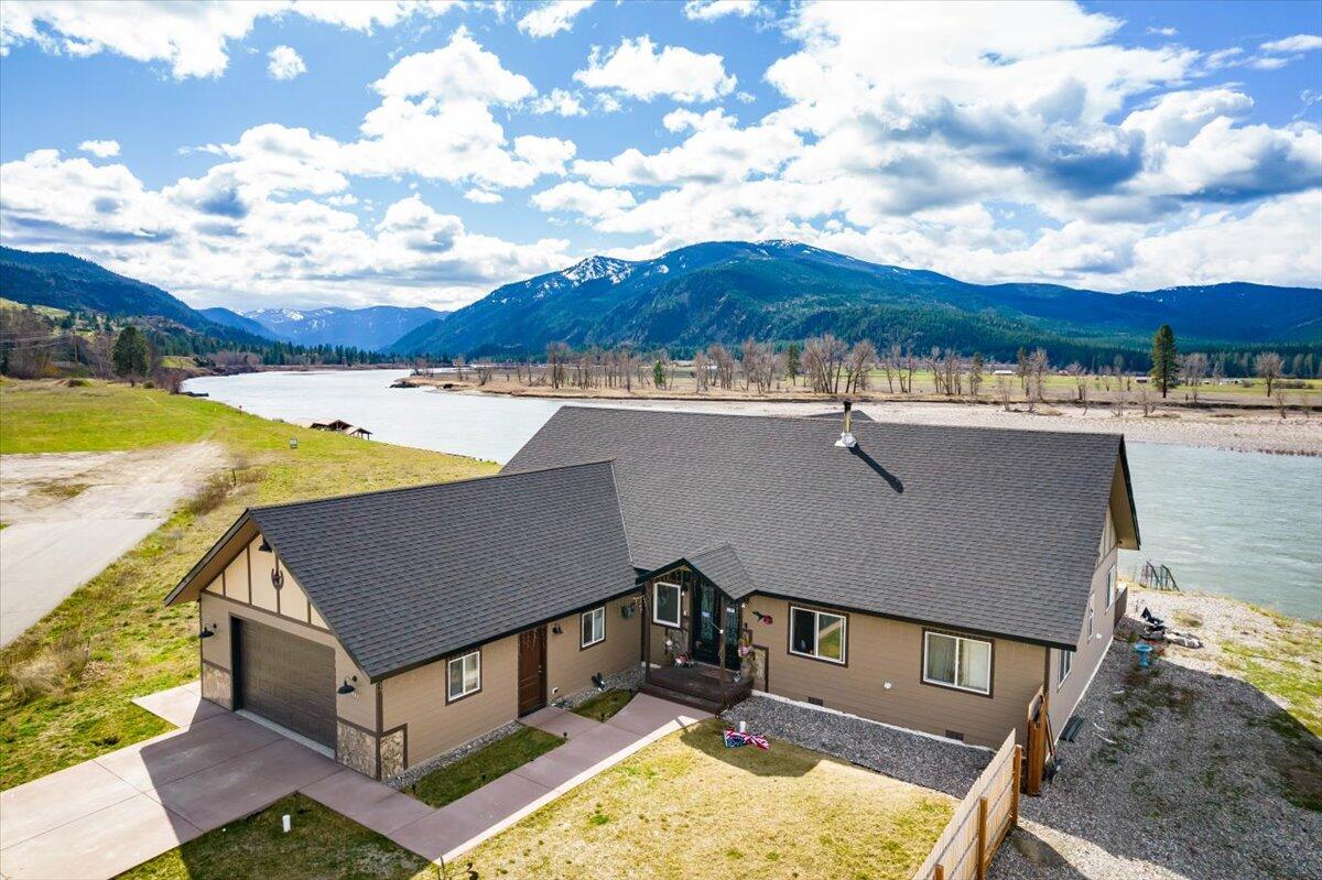 Beautiful Single story home overlooking the Clark Fork River with 80 ft of River frontage.  Unobstructed views!  Four bedrooms, 2 1/2 bathrooms.  Home has Smart Home Technology throughout. Large master suite with double vanity and walk-in closets, open floor plan, vaulted great room ceiling, upgraded features, Granite counter tops, custom hard-wood cabinetry, tiled entry, maintenance free siding, easy access to the deck out door kitchen. Community boat dock.Call Cyndy Glieden at 406-890-9150, or your real estate professional,