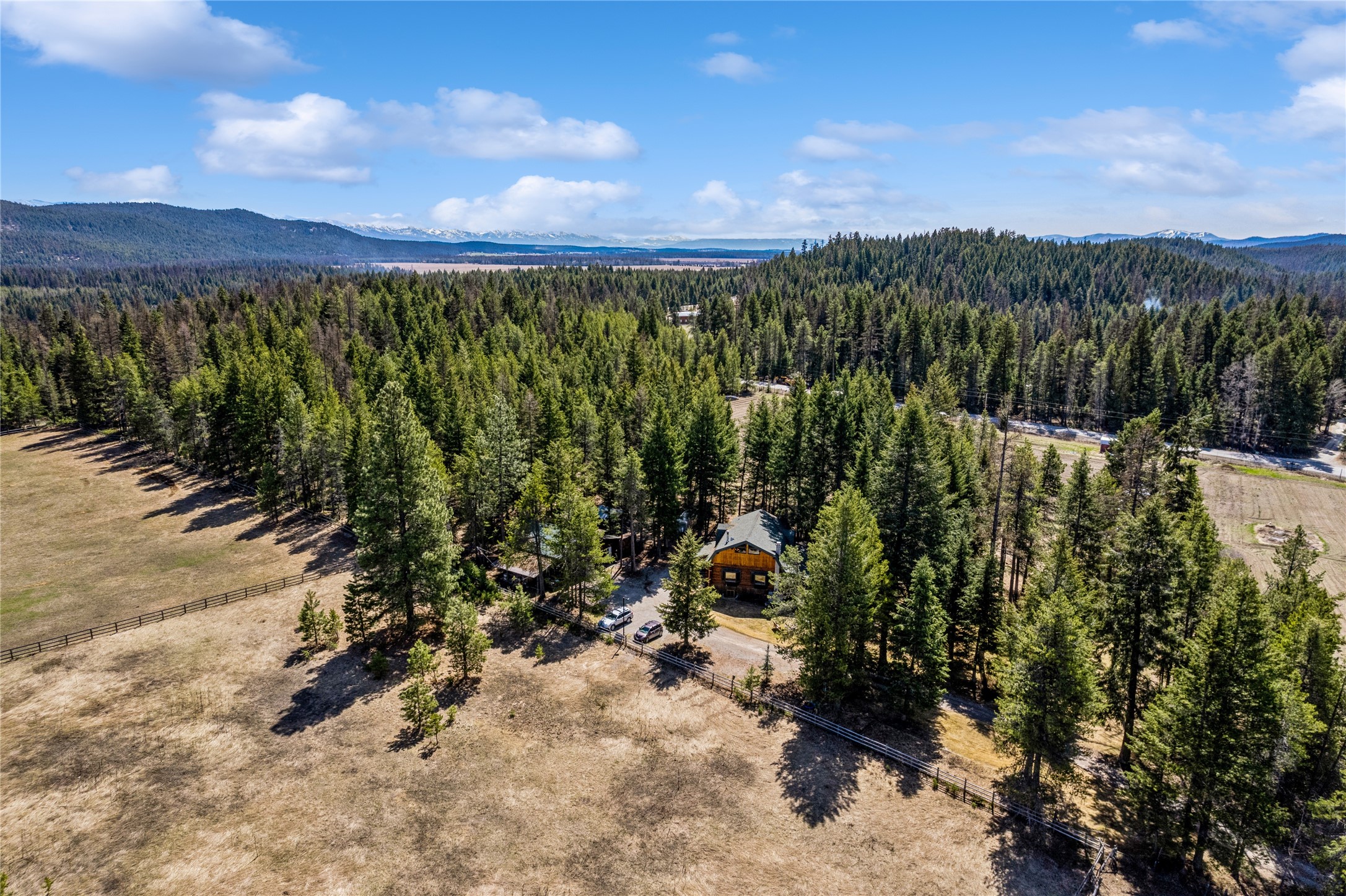SUBSTANTIAL PRICE IMPROVEMENT! One of a kind setting less than 10 minutes from downtown Whitefish that could be used for Short-term rentals. Brand new septic system in 2023. Privacy on ~3 parked out acres perfect for the horse enthusiast or gardener! Beautiful custom home with massive 18'' logs, vaulted ceilings, and the main level deck and walk-out patio are perfect for cozy living or incredible entertaining. House boasts a separate upper-level primary suite with attached bathroom, sitting area, and private porch to enjoy a morning coffee. Additional living space to be enjoyed in the daylight finished lower level with 3 bedrooms, full bathroom, laundry, and office space. Large detached shop is perfect for all your toys and other hobbies along with a full-finished 300sqft studio area. Rural living that offers easy access to recreational paradise yet close to all the amenities of both Whitefish and Kalispell. Contact Lindsey LivingGood at 406-270-4453, or your real estate professional.