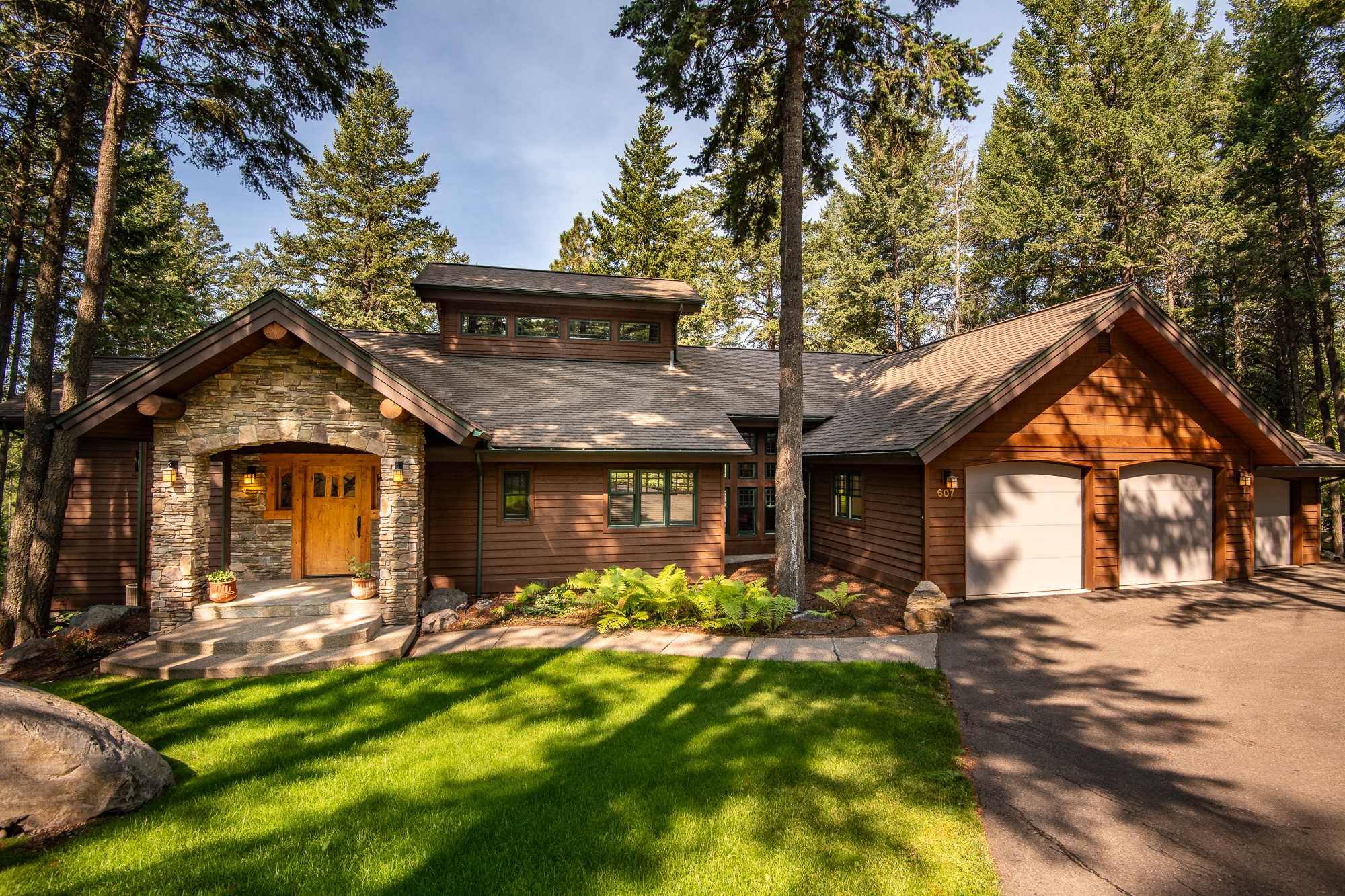 Impeccably Crafted Lodge-Style Living - Past Winner of the Parade of Homes, this 4-bedroom, 3-bathroom home built by Stoddard Construction Company offers a truly unique residence with its flawless style, incredible features and phenomenal views of Flathead Lake and Blacktail Mountain. Step inside beyond the stunning stone porch and hand-crafted front door and fall in love with the custom Greene and Greene architectural firm-inspired interior, complete with huge log beams & accents, and quarter sawn white oak flooring. Elegantly designed, the floor plan provides 4,350 sq. ft. of living space. The living room surrounds a massive stone fireplace and the large dining area opens out to the deck - perfect for drinks while taking in those gorgeous views. Back inside, the gourmet kitchen comes fitted with impeccable knotty alder distressed cabinetry, built-ins, and KitchenAid commercial-grade appliances, including a 6-burner gas range and wine cooler. The study is fully soundproofed for a home theatre, and the family room features 100+ year old fir beams and a matching mantlepiece on the gas fireplace. All the bedrooms offer an incredible sanctuary for the end of each day, with the main floor primary bedroom receiving the deluxe treatment with a private ensuite straight out of a 5-star resort. Fitted out for convenient contemporary living, the home also features a "Super Smart Computer System" accessible via phone and a central vacuum system. The attached 3-car garage is wired for a woodworking shop. Two central forced-air heating systems keep the interior comfortable, and a combination of Weather Shield Dual Glaze, low E insulated, clad windows manufactured in Alder wood, R-38 insulated ceilings and R-23 bib insulation in all the walls for energy efficiency. Call Jeanie Deetz at (406) 270-1942, or your real estate professional.