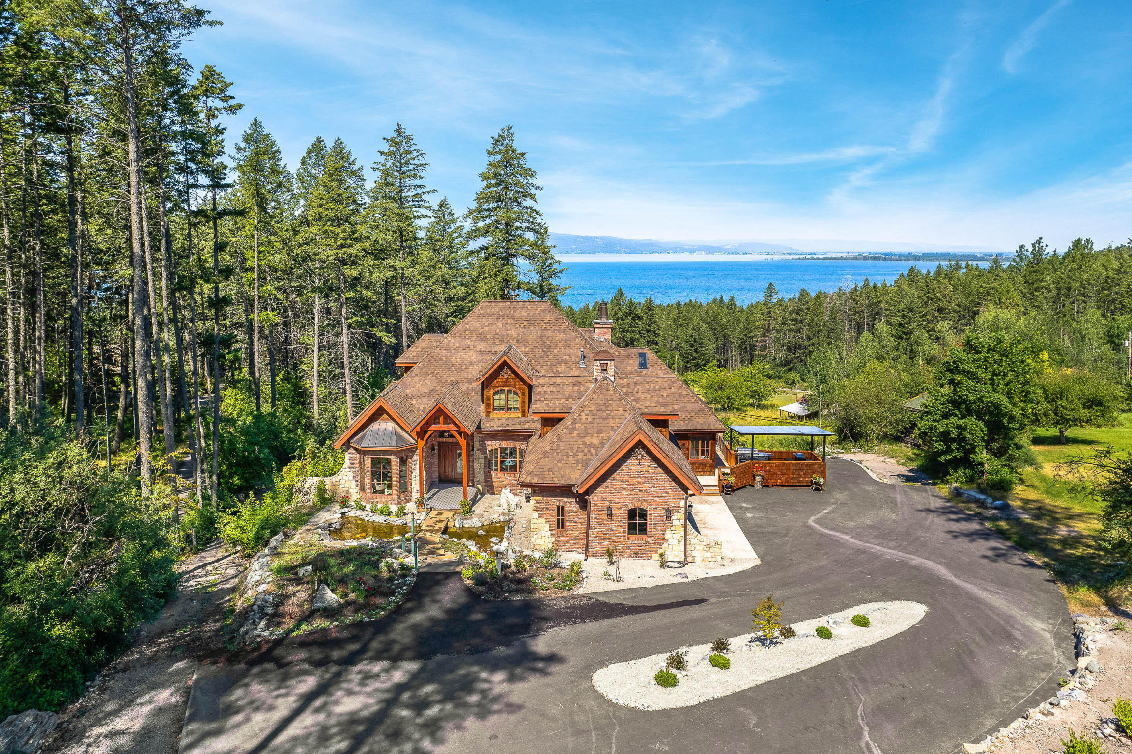 A visionary’s masterpiece! Welcome to this elegant Manor House, bringing w/ it a touch of old-world opulence, multi-cultural glamour, & breathtaking Flathead Lake & sunset views. This spectacular 5BD/7BA 6,647 SF residence settled on 1 acre boasts no HOA/CCRs and is just minutes from the artisan village of Bigfork. Bring relaxation & serenity into your day surrounded by the meticulously handcrafted elements of this elaborate home. Entertain gatherings of every size from your huge chef's kitchen, dining area, large covered deck, or the cozy wine grotto. The home features a complete in-law suite with 2 bedrooms and a separate kitchen with separate private access. Settle into your own slice of Northwest MT, where Glacier National Park and more adventure awaits. See Feature Sheet in docs for more information. Furnishings negotiable, personal property list provided upon request. Call Jennifer Shelley at 406.249.8929, Hannah Shelley at 406.270.0794, or your real estate professional.