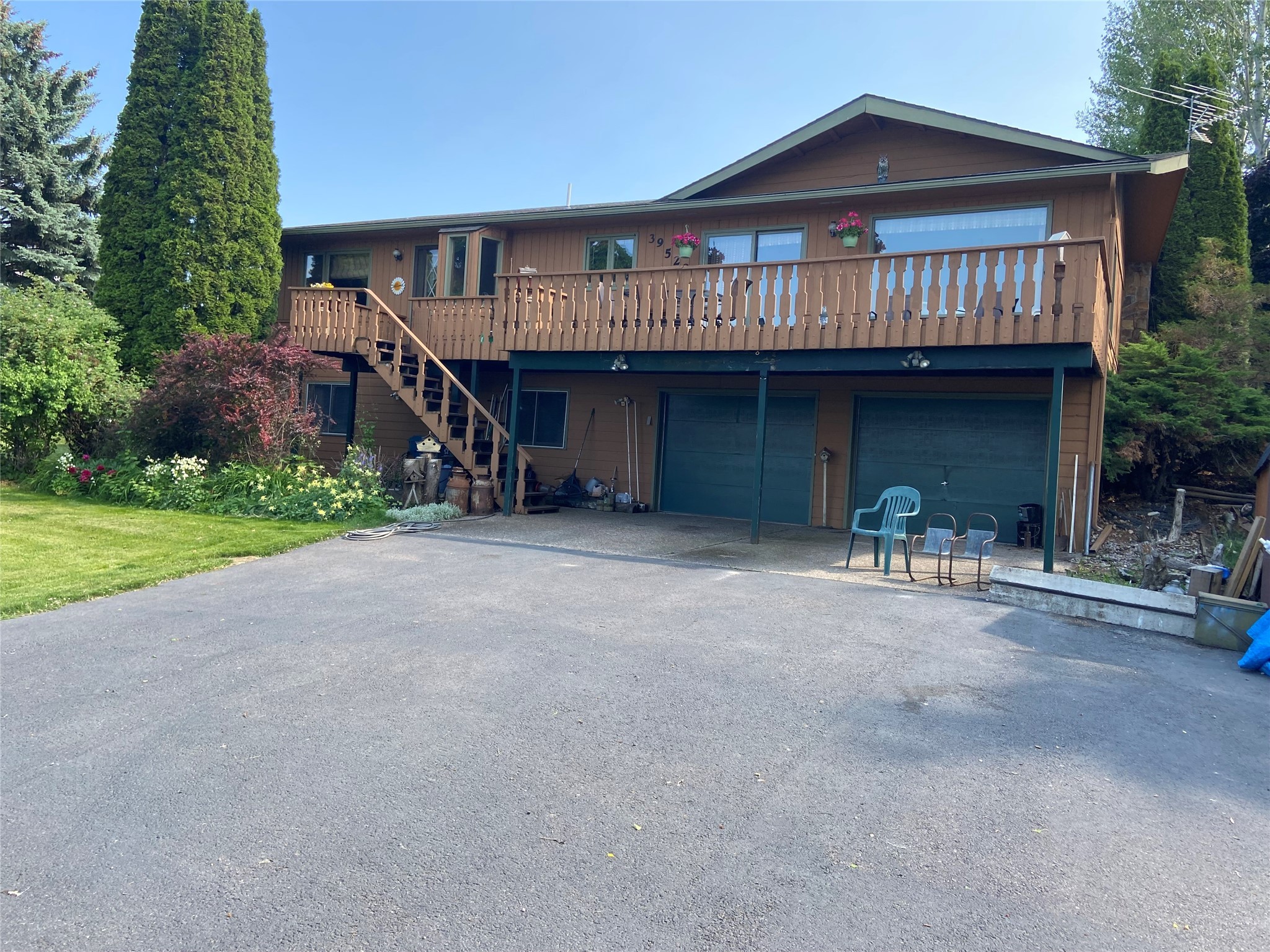 Priced Below Recent Appraisal. For a full price, acceptable offer, sellers will credit buyers $10,000 towards an interest rate buydown at closing. Beautiful Lake and Mountain Views, Private "end-of-the-road" location. 2,320 SF, 3 Bedroom, 3 Bath home with deep "Tuck-Under" garage. Main level Great Room, dining area with warm golden wood, "tongue and groove" walls and raised ceiling.  Magnificent views. A balcony deck expands warm weather outdoor living. U-shaped kitchen has newer appliances; refrigerator, oven/range with all the latest features and dishwasher. Ample counter space and cabinets. Master suite includes 3/4 bath and laundry area. Second bedroom and full bath. Drive wraps around to entrance in back for easy access to main level.
Lower level has outside entrance, full kitchen, 3rd bedroom with built-ins, Full bath with "Jetted-Tub" and 
attached  sauna. Family room/den has wood stove and the shelving unit will remain. Garage has propane stove.
Shared Well. 2 Parties. Orchard has apricots, apples, pears, cherries and plums. Fenced in garden area. Storage unit garden shed in back  Barn shaped storage shed in front on right side will remain. Yard is surrounded in back by evergreens and deciduous trees and shrubs.  Many perennials throughout property and many mature trees in front and side of property.  underground sprinklers. Oversized "Tuck-Under" garage has storage area and fruit room.